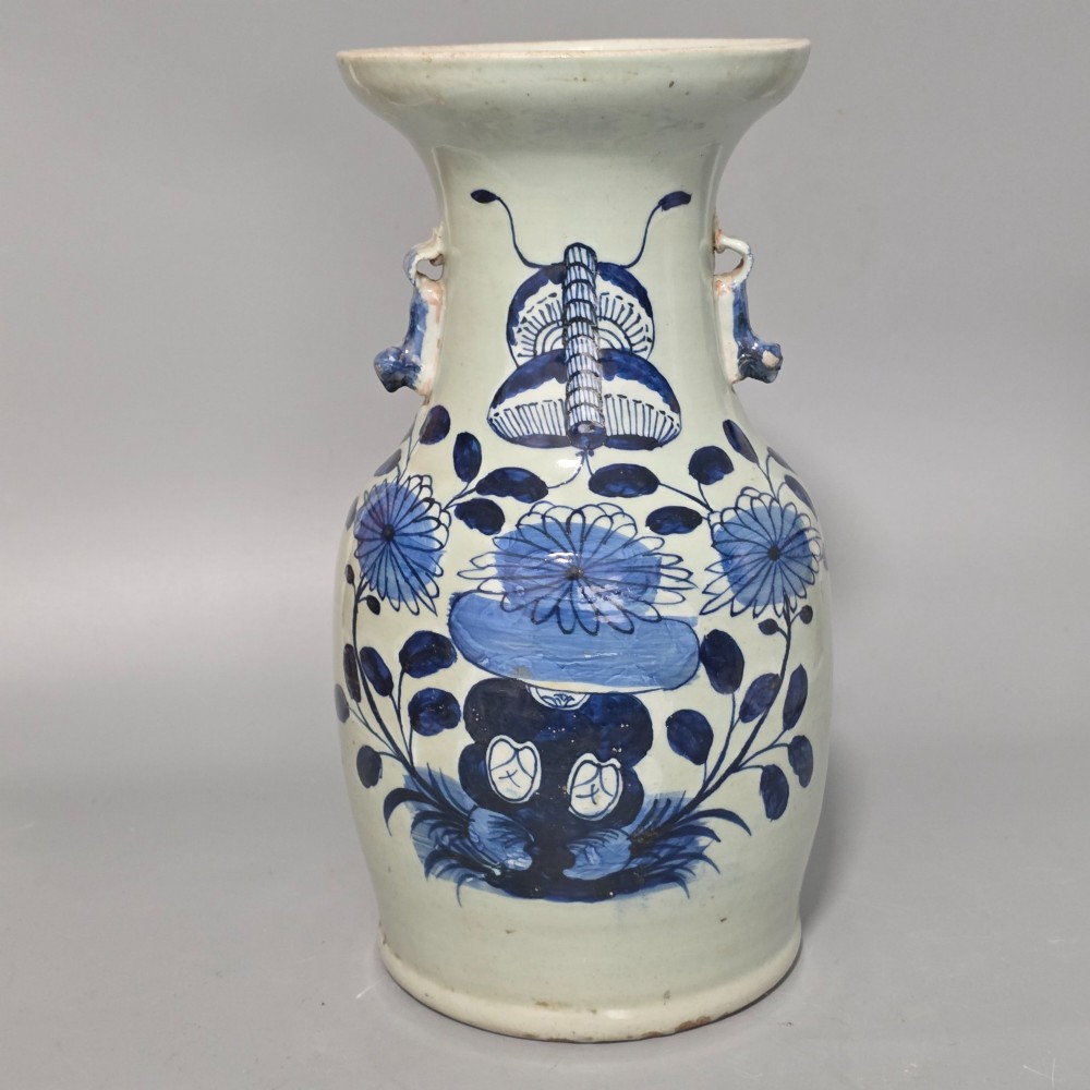 A 19th-century Chinese baluster porcelain vase featuring a pale celadon glaze decorated with hand-painted cobalt blue floral motifs and moulded neck handles.