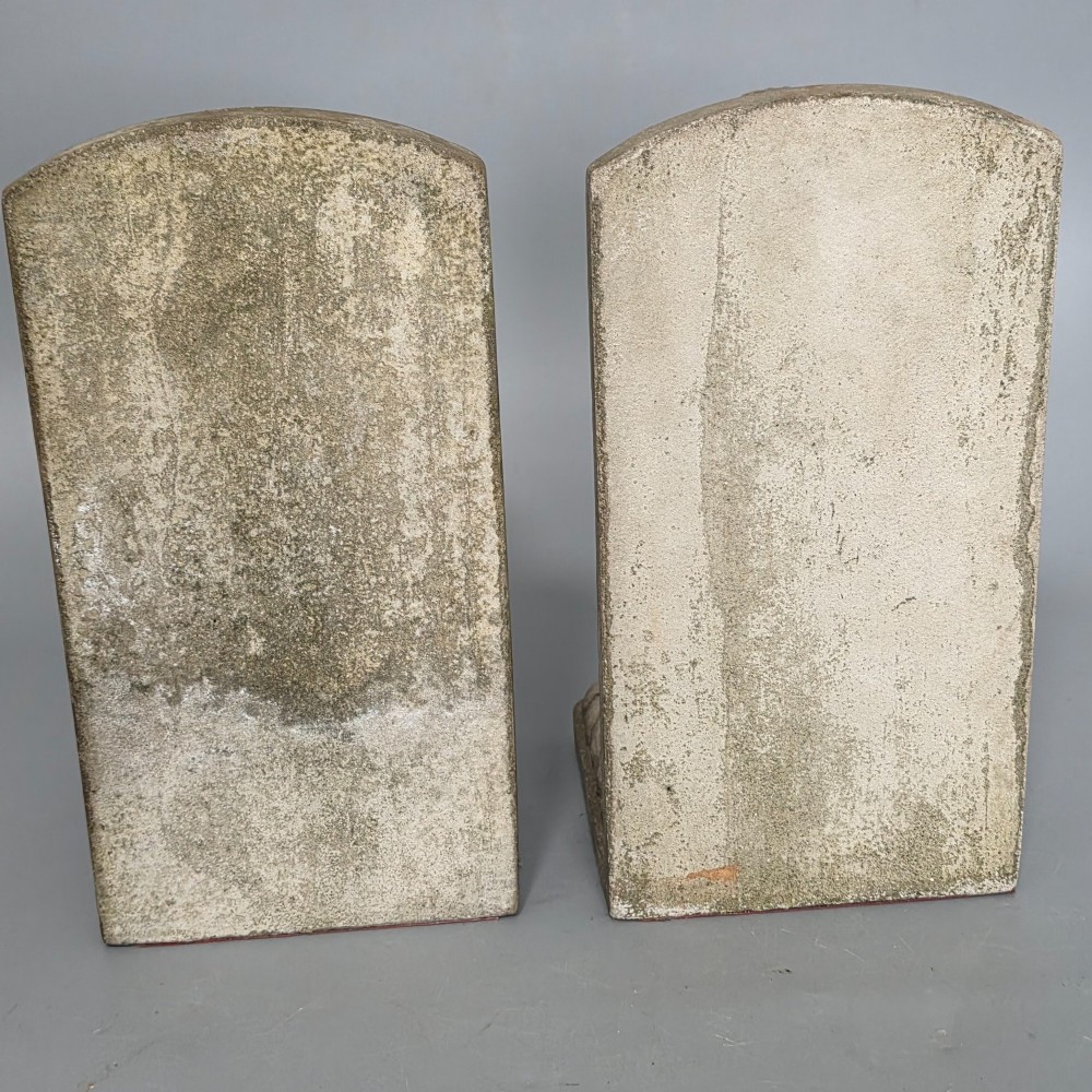 A pair of grey cast stone bookends sculpted as seated lions holding shields featuring a fleur-de-lis motif. View III