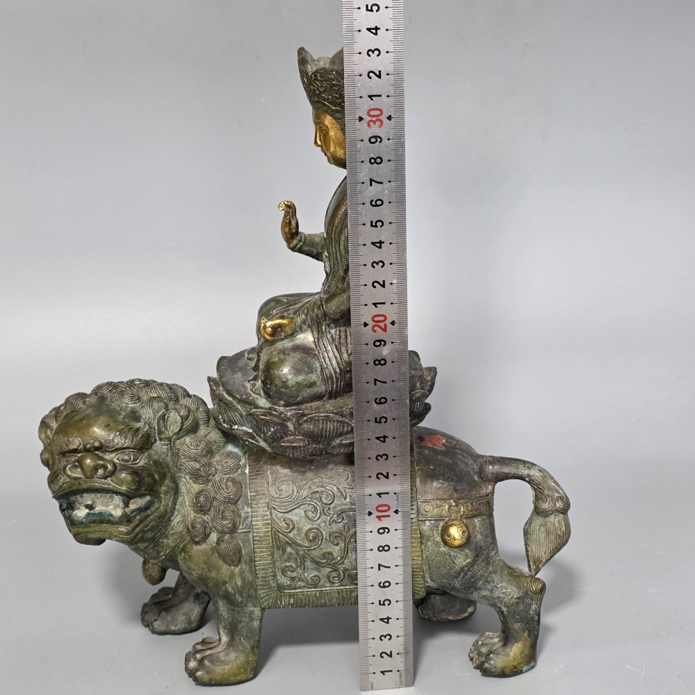 A 19th-century cast bronze sculpture depicting a seated Guanyin figure with gilded facial details riding atop a textured Dog of Fo. View III
