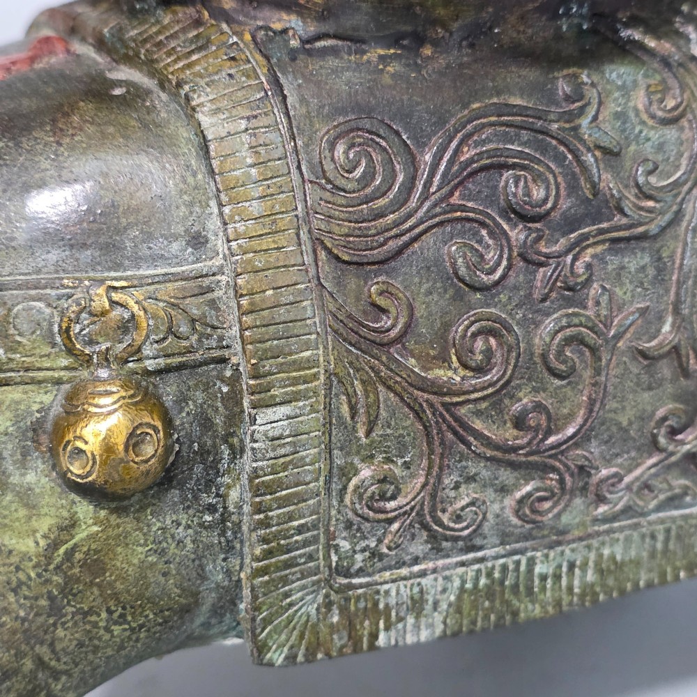 A 19th-century cast bronze sculpture depicting a seated Guanyin figure with gilded facial details riding atop a textured Dog of Fo. View XIII