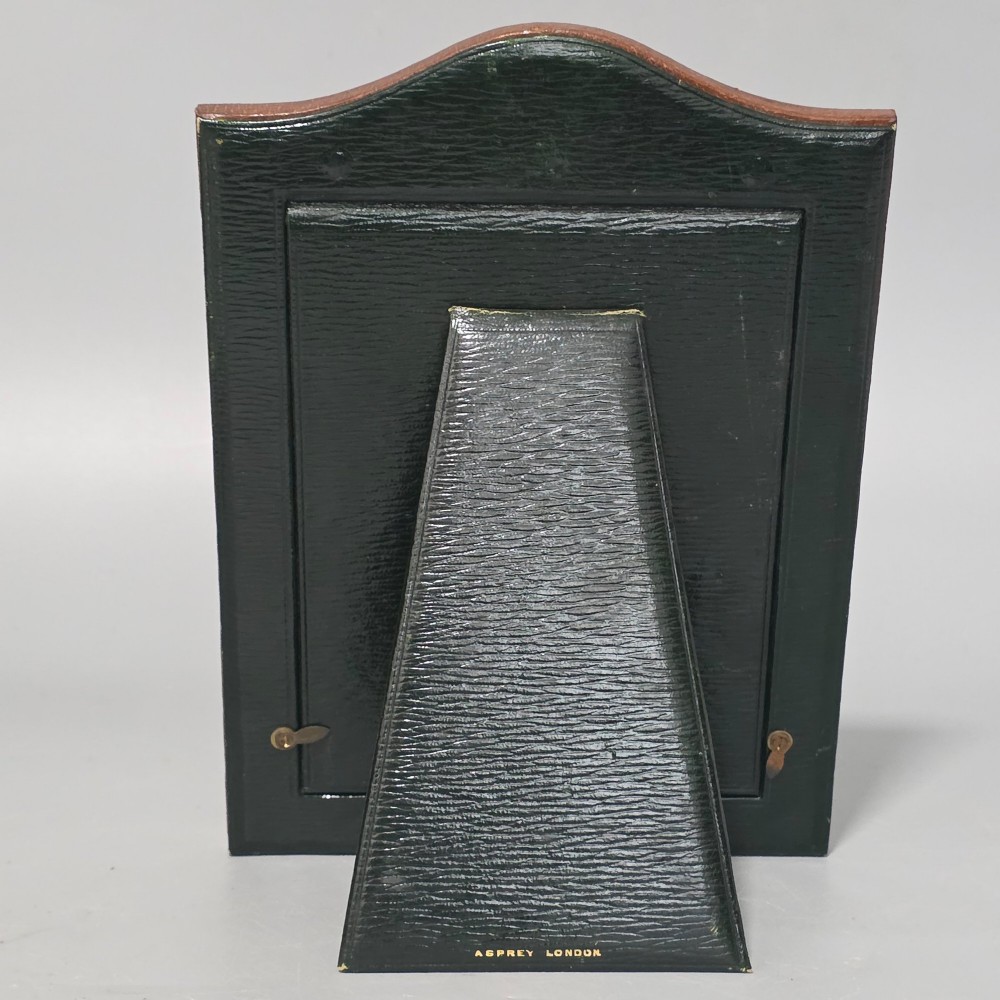 A brown textured leather photo frame featuring an arched top and a central rectangular aperture backed with moire silk. View VII