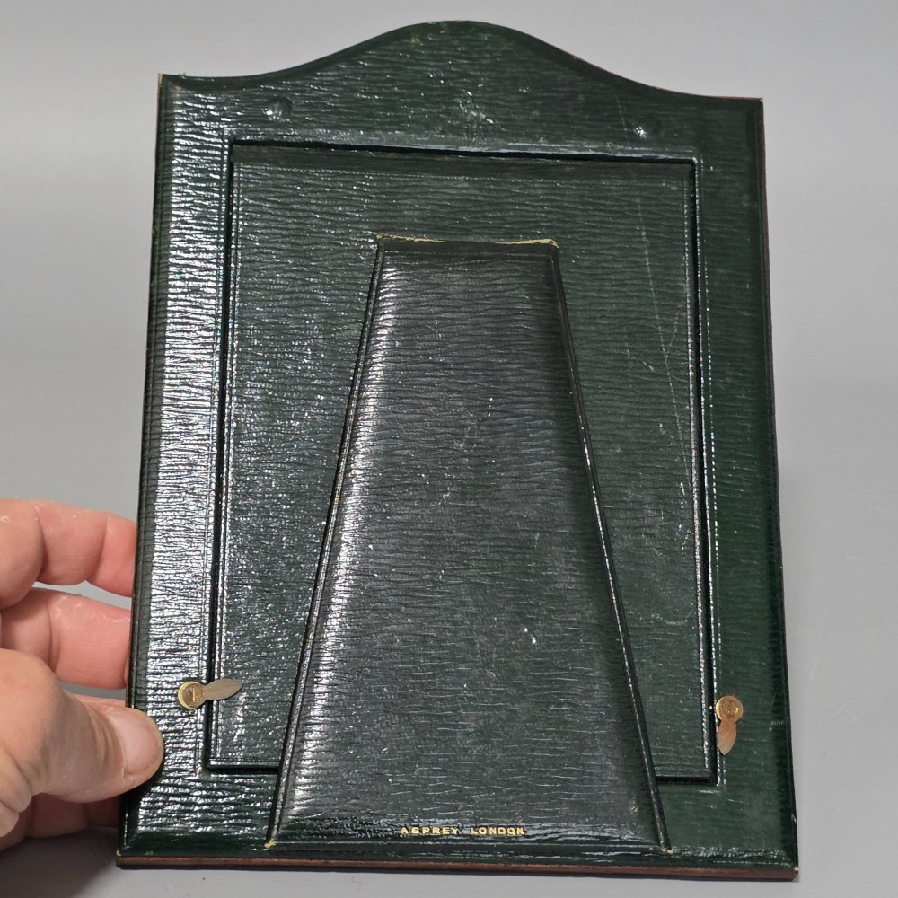 A brown textured leather photo frame featuring an arched top and a central rectangular aperture backed with moire silk. View XII