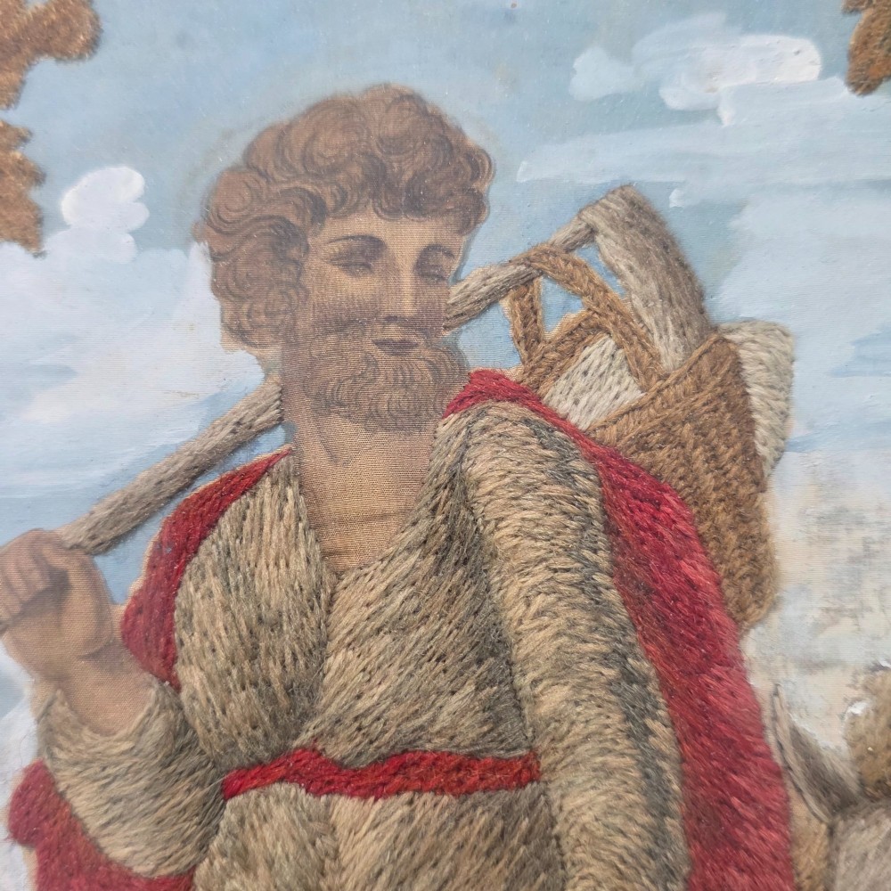 A framed Georgian silkwork and woolwork picture depicting the Flight into Egypt inside an oval glass reserve and a giltwood frame. View IV