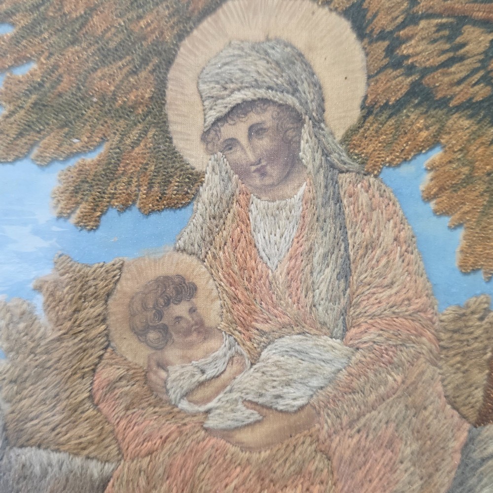 A framed Georgian silkwork and woolwork picture depicting the Flight into Egypt inside an oval glass reserve and a giltwood frame. View VI