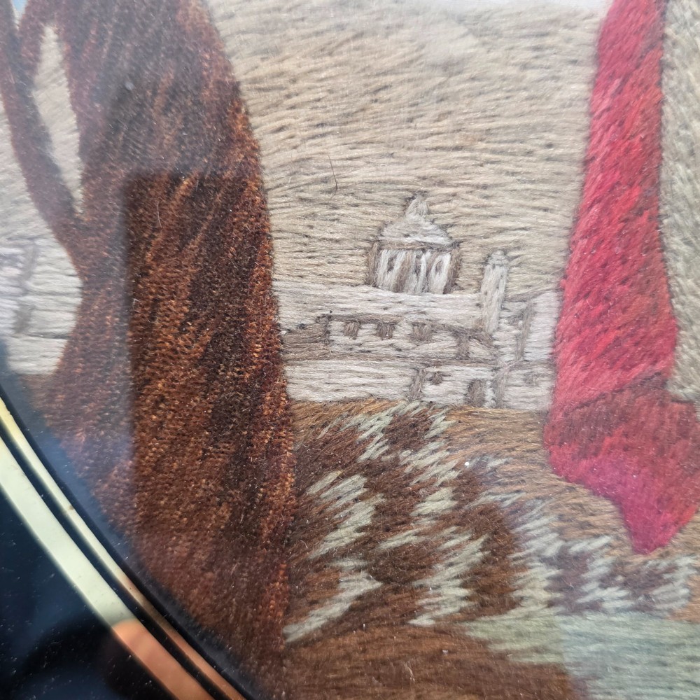 A framed Georgian silkwork and woolwork picture depicting the Flight into Egypt inside an oval glass reserve and a giltwood frame. View VII