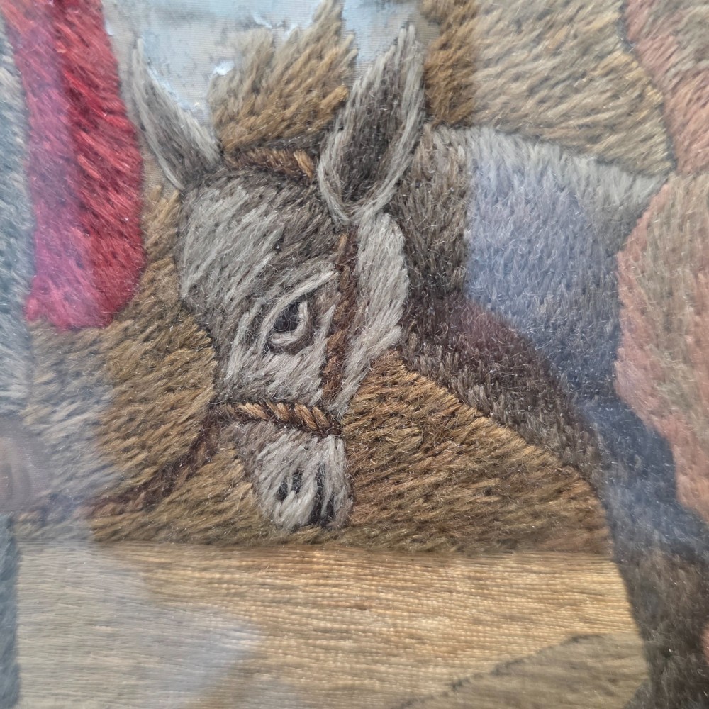 A framed Georgian silkwork and woolwork picture depicting the Flight into Egypt inside an oval glass reserve and a giltwood frame. View IX