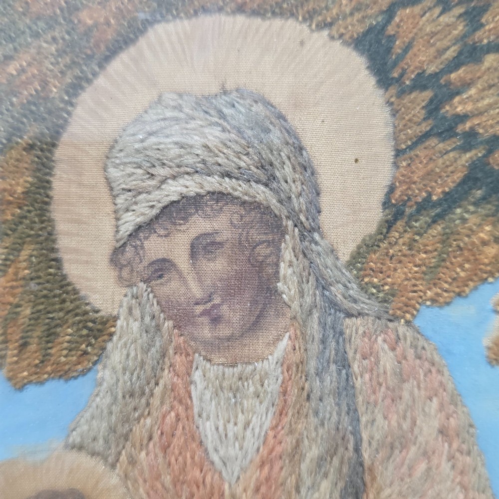 A framed Georgian silkwork and woolwork picture depicting the Flight into Egypt inside an oval glass reserve and a giltwood frame. View XV