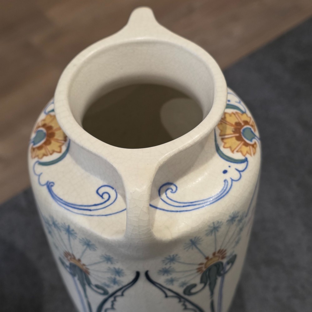 A pair of tall cream ceramic Art Nouveau vases featuring integral twin handles and hand-painted purple and green stylised floral motifs. View V