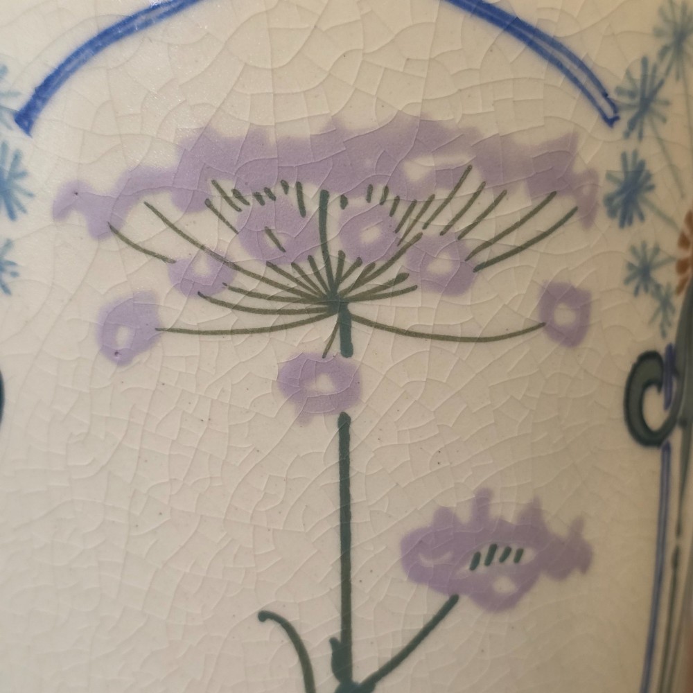 A pair of tall cream ceramic Art Nouveau vases featuring integral twin handles and hand-painted purple and green stylised floral motifs. View XI