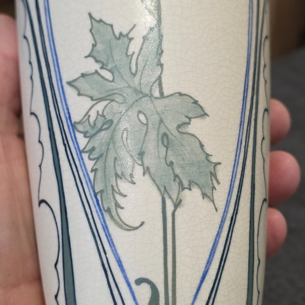 A pair of tall cream ceramic Art Nouveau vases featuring integral twin handles and hand-painted purple and green stylised floral motifs. View XIII