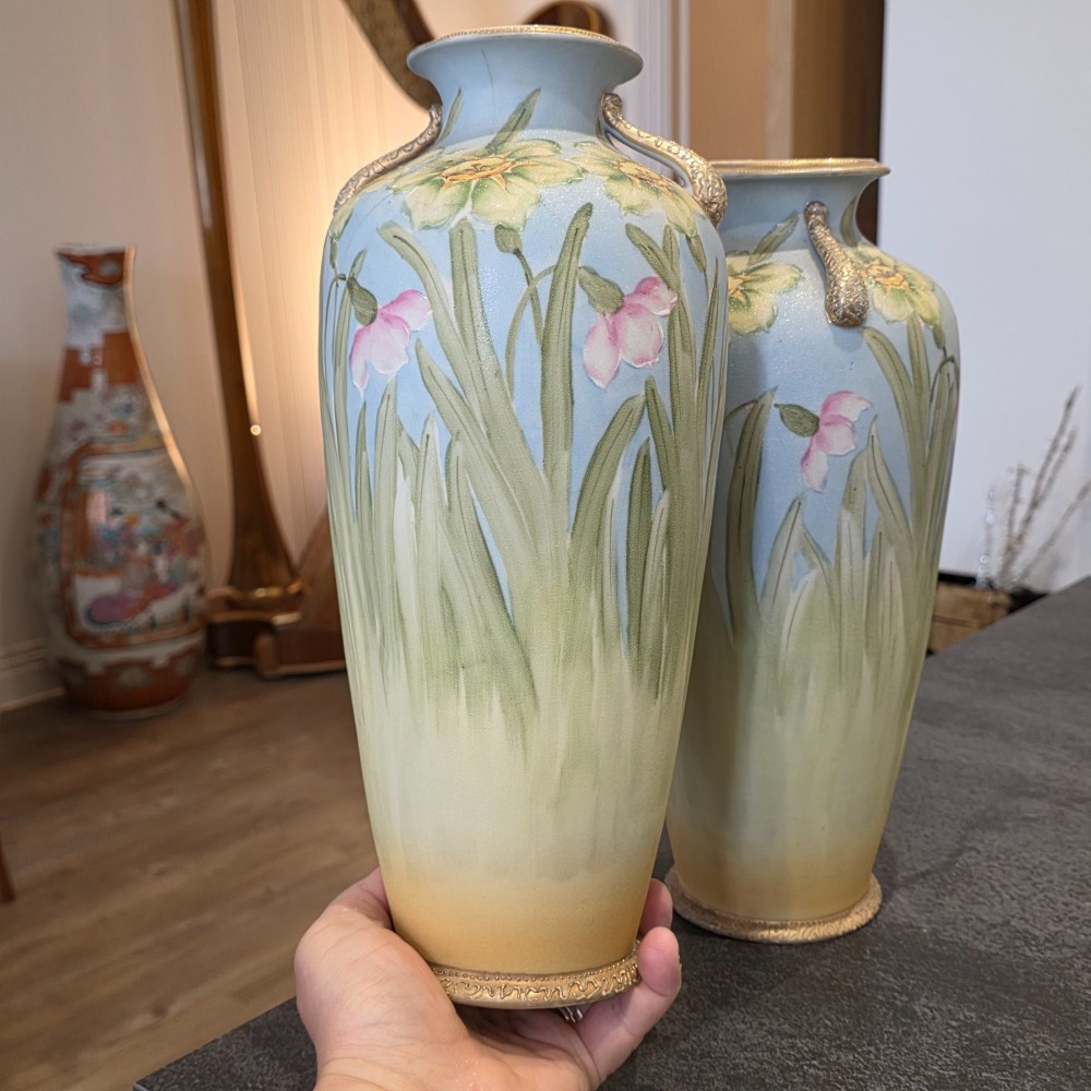 A pair of baluster-shaped porcelain vases featuring hand-painted daffodil and blossom motifs over a light blue and yellow gradient background with small gilded handles. View III