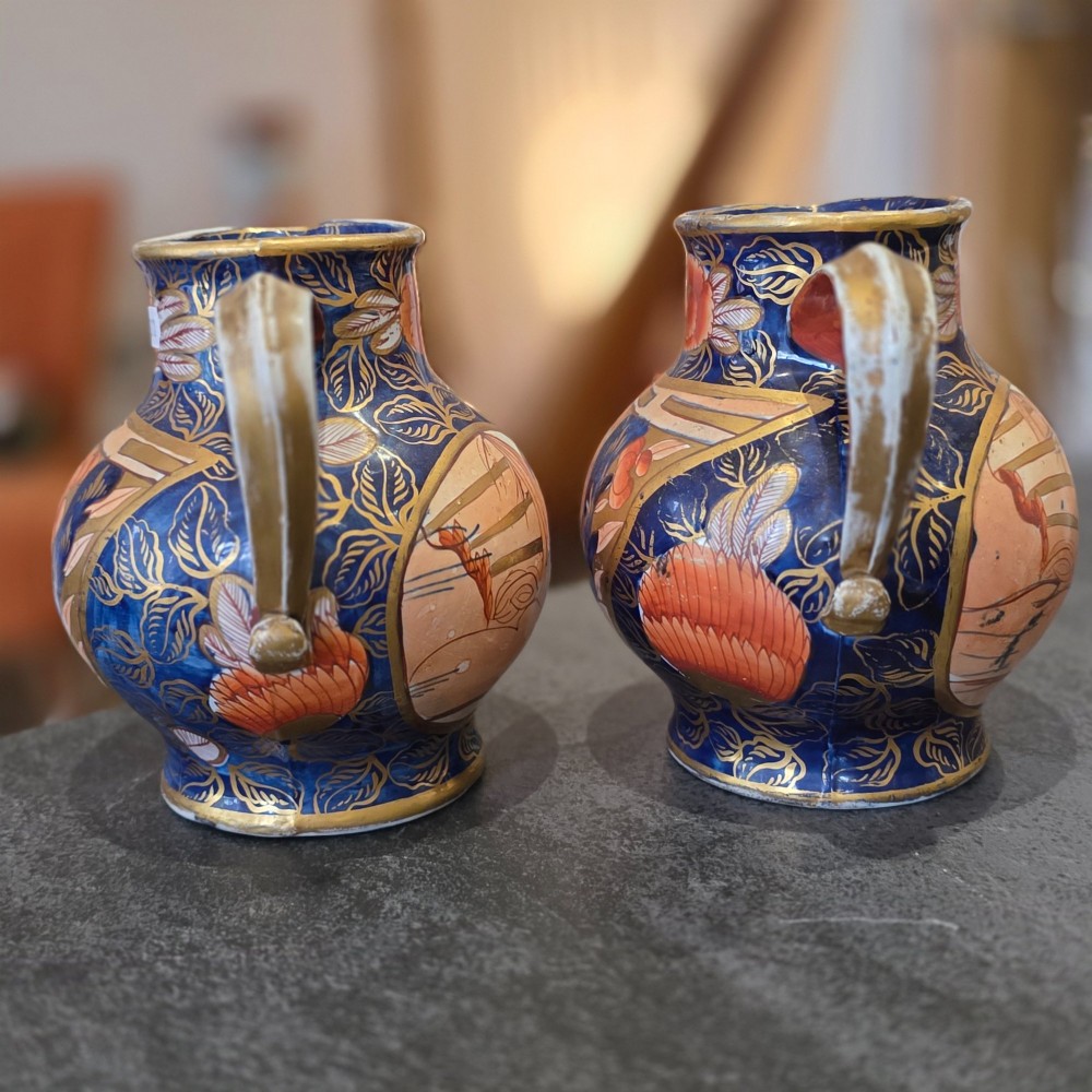 A pair of bulbous stoneware jugs decorated in cobalt blue, terracotta, and gold Imari style patterns with raised handles. View III