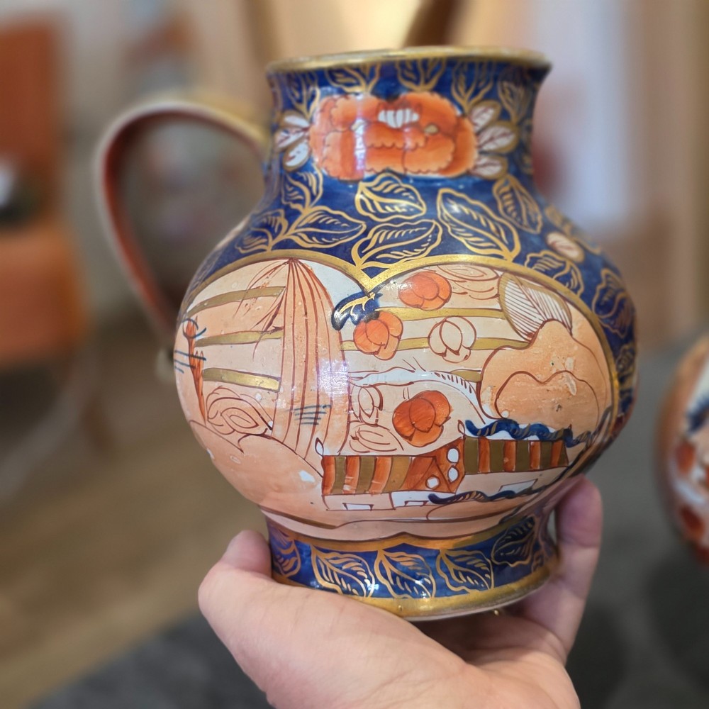 A pair of bulbous stoneware jugs decorated in cobalt blue, terracotta, and gold Imari style patterns with raised handles. View VII