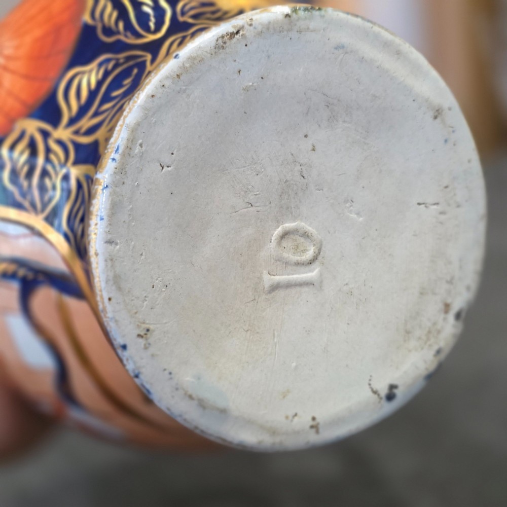 A pair of bulbous stoneware jugs decorated in cobalt blue, terracotta, and gold Imari style patterns with raised handles. View VIII