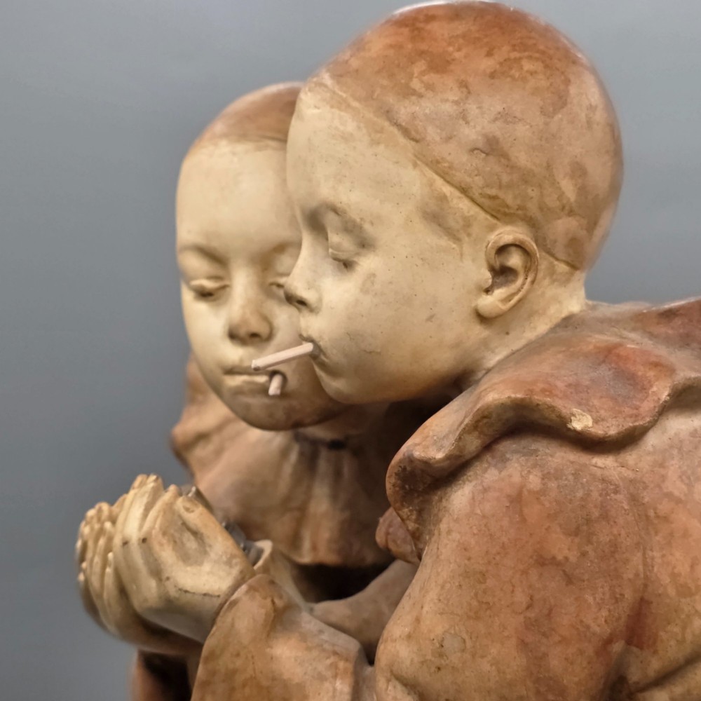A terracotta sculpture featuring two Pierrot figures in ruffled collars standing together on an oval plinth, designed as a lamp base. View VII