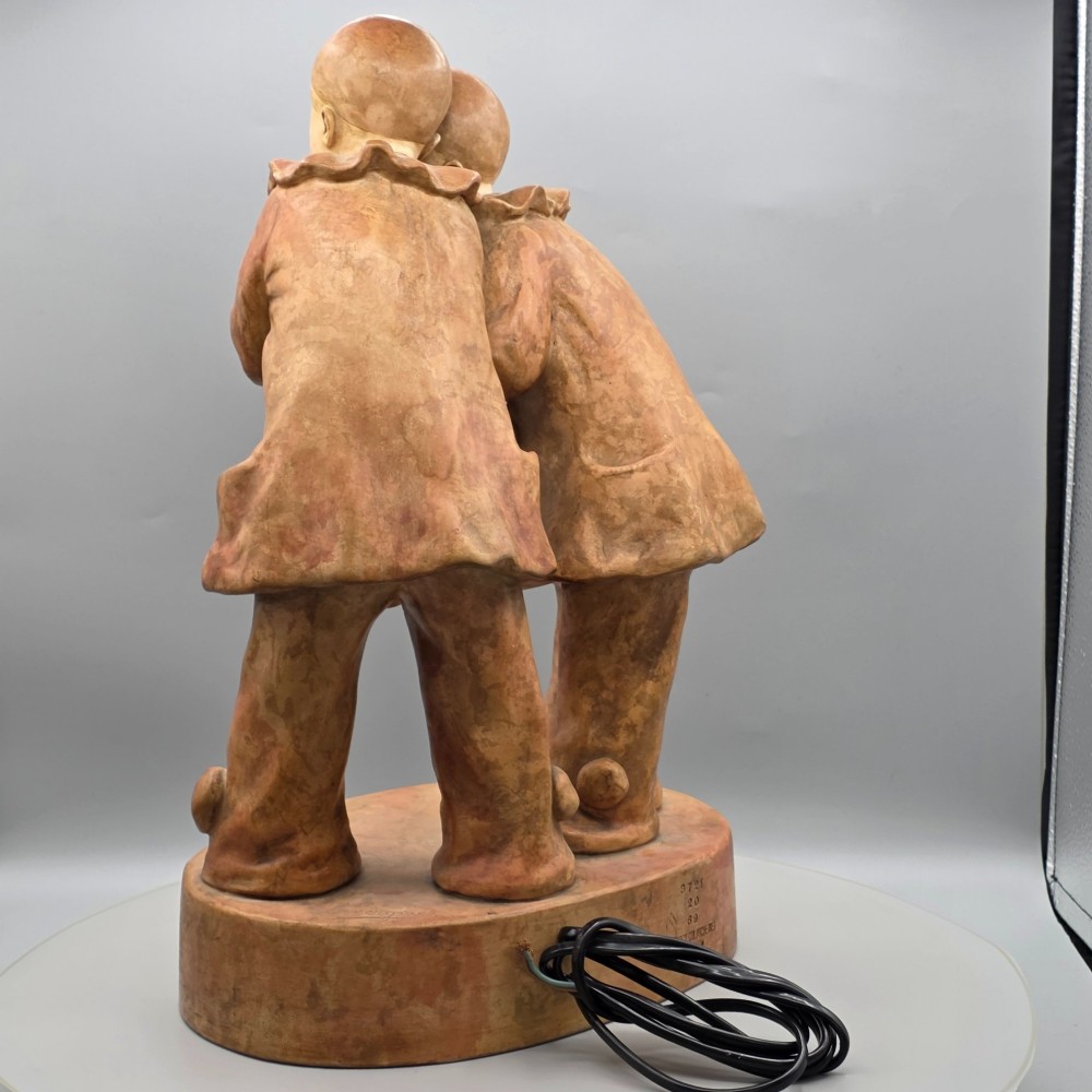 A terracotta sculpture featuring two Pierrot figures in ruffled collars standing together on an oval plinth, designed as a lamp base. View VIII