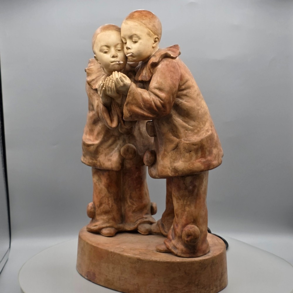 A terracotta sculpture featuring two Pierrot figures in ruffled collars standing together on an oval plinth, designed as a lamp base. View IX