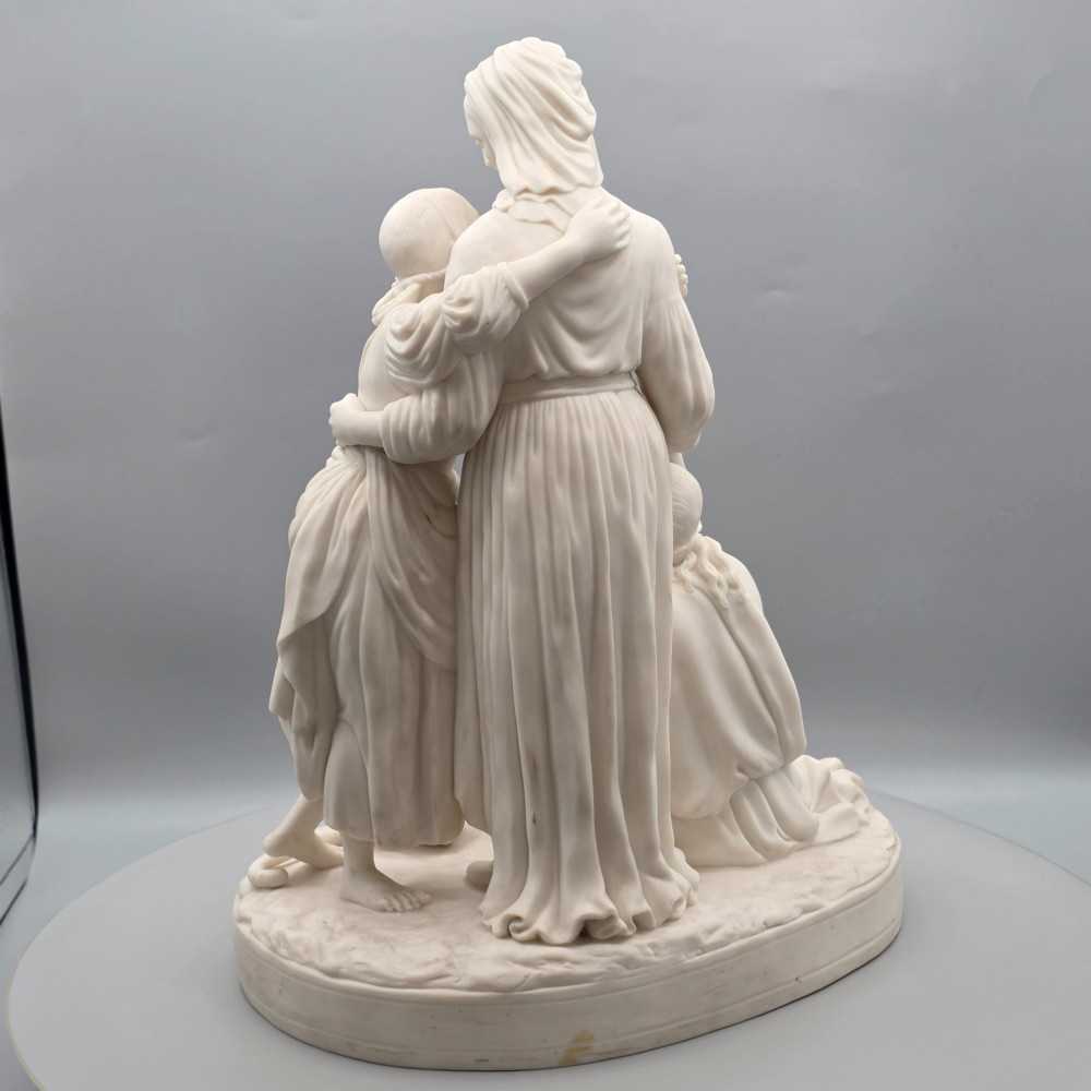 A Victorian off-white parian porcelain figural group depicting three women in classical draped robes on an oval base. View VI