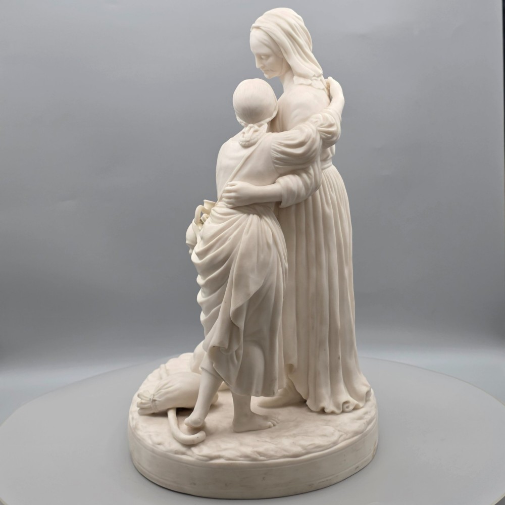 A Victorian off-white parian porcelain figural group depicting three women in classical draped robes on an oval base. View VII