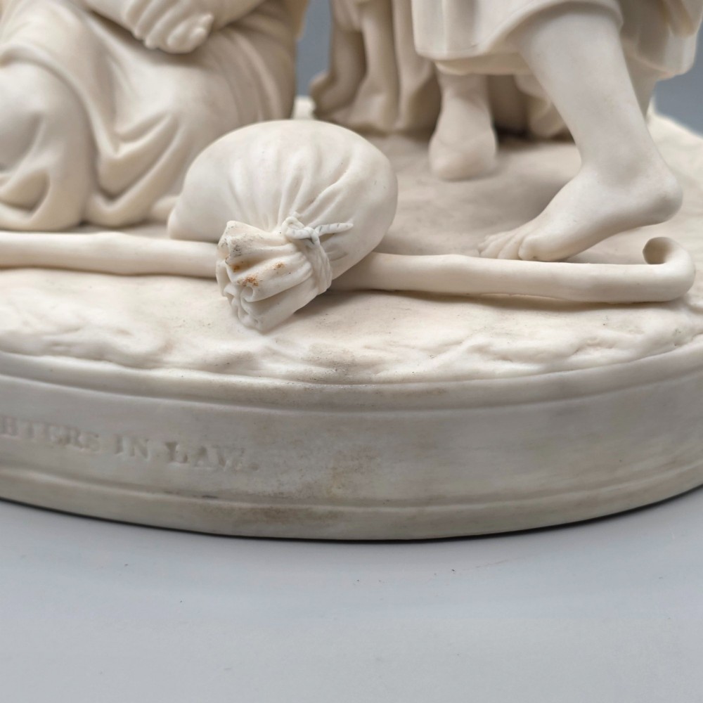 A Victorian off-white parian porcelain figural group depicting three women in classical draped robes on an oval base. View VIII