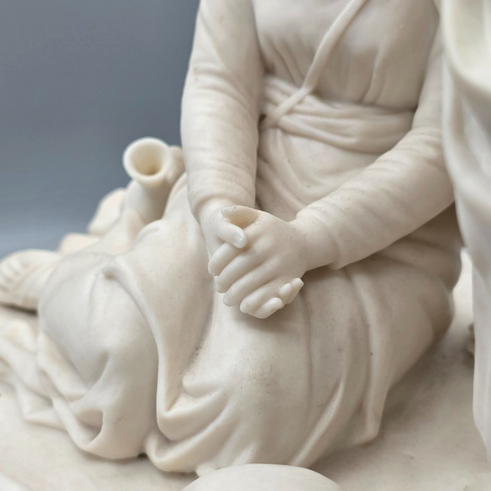 A Victorian off-white parian porcelain figural group depicting three women in classical draped robes on an oval base. View IX