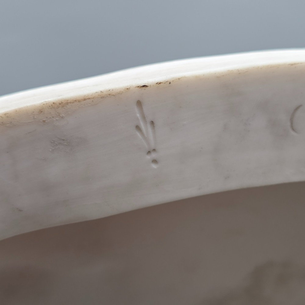 A Victorian off-white parian porcelain figural group depicting three women in classical draped robes on an oval base. View XIV