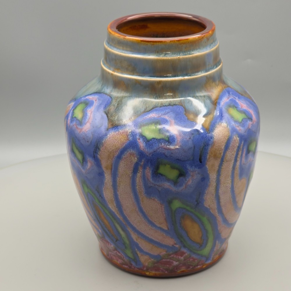 An Art Nouveau baluster-shaped stoneware vase with a stepped rim, featuring vibrant blue, pink, green, and ochre glazes forming abstract floral motifs. View VIII