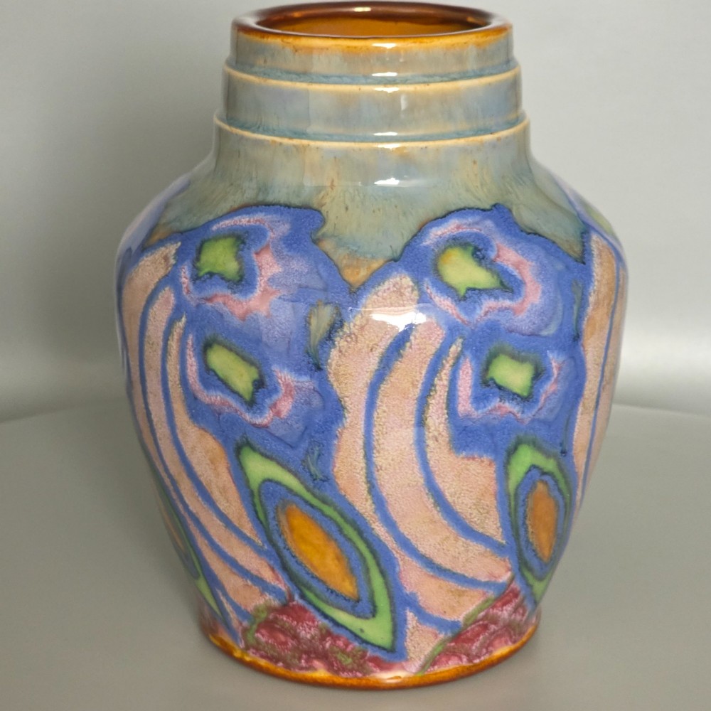 An Art Nouveau baluster-shaped stoneware vase with a stepped rim, featuring vibrant blue, pink, green, and ochre glazes forming abstract floral motifs. View XI