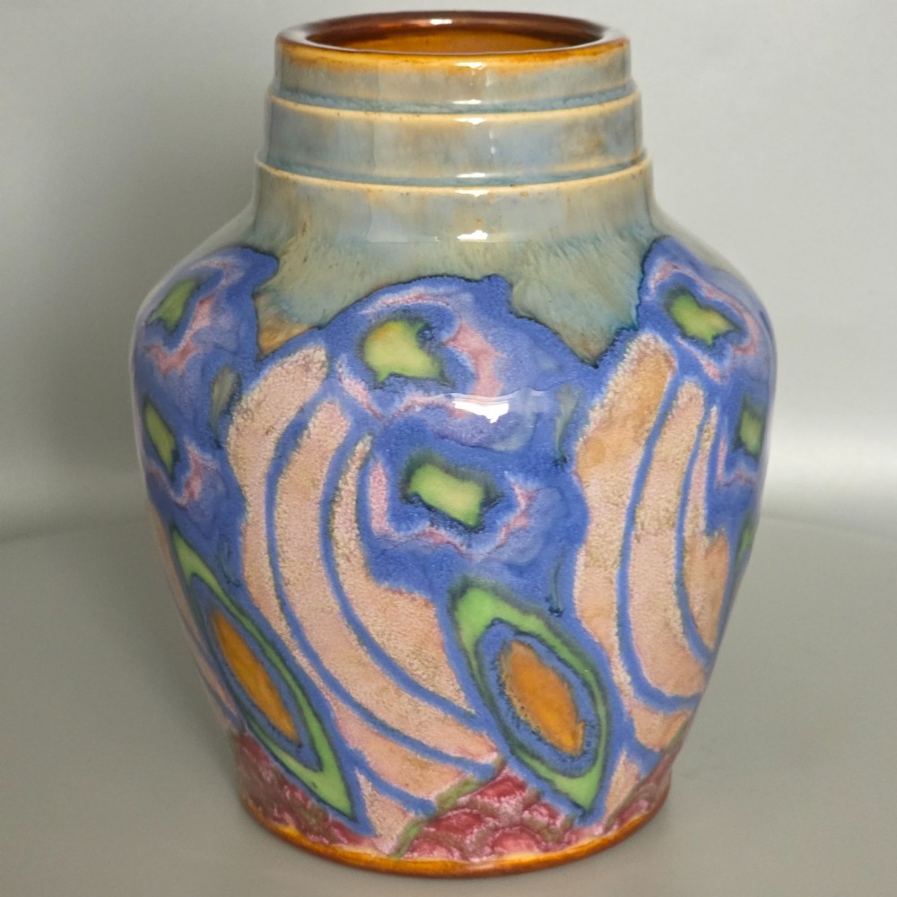 An Art Nouveau baluster-shaped stoneware vase with a stepped rim, featuring vibrant blue, pink, green, and ochre glazes forming abstract floral motifs. View XII