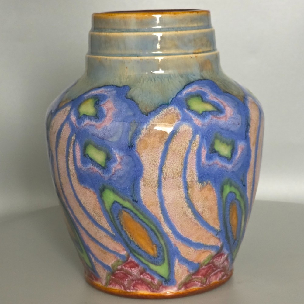 An Art Nouveau baluster-shaped stoneware vase with a stepped rim, featuring vibrant blue, pink, green, and ochre glazes forming abstract floral motifs. View XIII