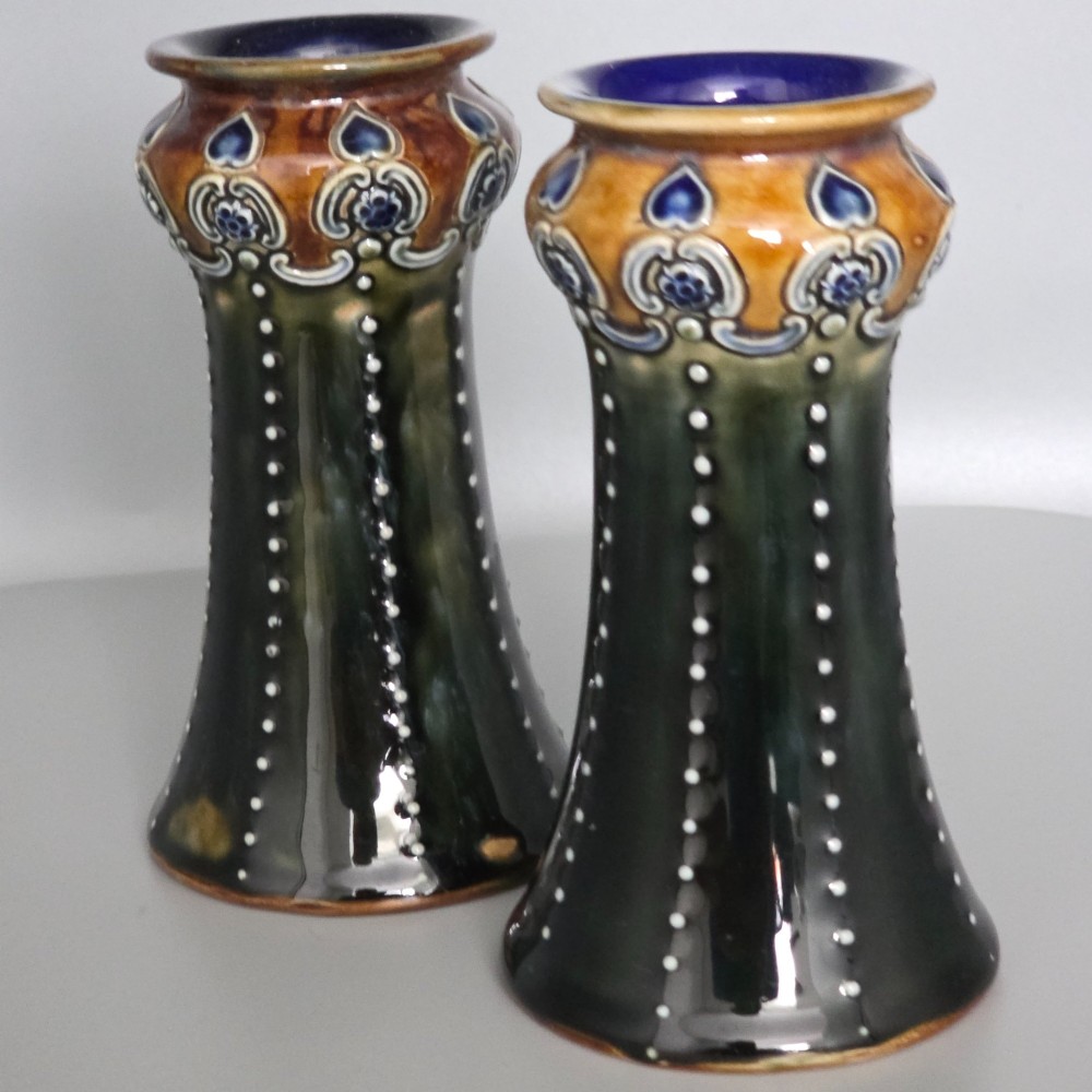 A pair of 1920s Royal Doulton Art Nouveau stoneware vases featuring flared bases, mottled dark green and brown glazes, and beaded shoulder decorations with blue accents. View III