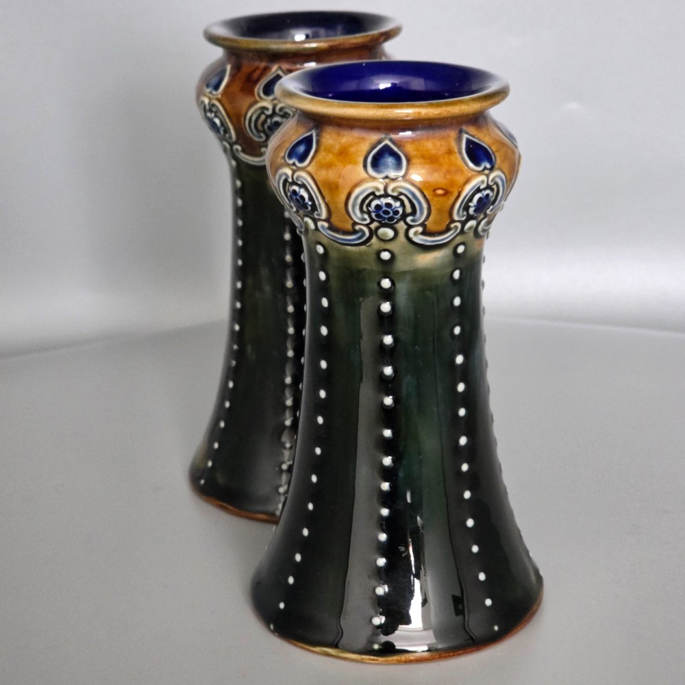 A pair of 1920s Royal Doulton Art Nouveau stoneware vases featuring flared bases, mottled dark green and brown glazes, and beaded shoulder decorations with blue accents. View IV