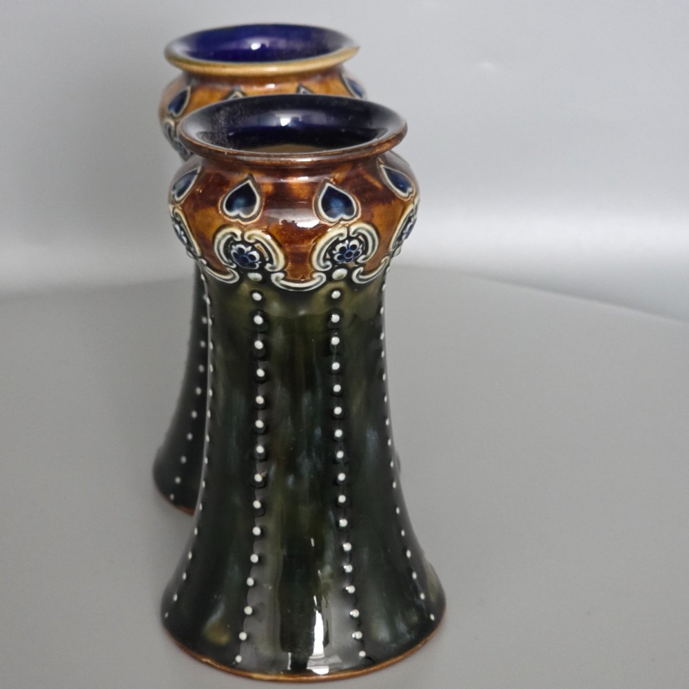 A pair of 1920s Royal Doulton Art Nouveau stoneware vases featuring flared bases, mottled dark green and brown glazes, and beaded shoulder decorations with blue accents. View XIII