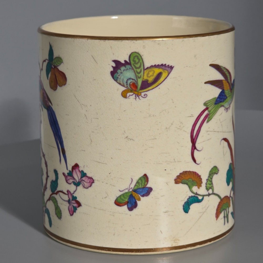 A large cream porcelain mug decorated with hand-painted polychrome birds, insects, flowers, and a gilded rim. View II