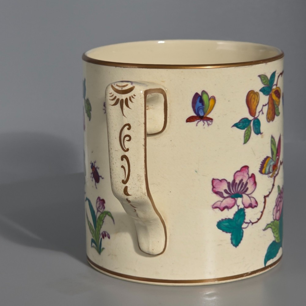 A large cream porcelain mug decorated with hand-painted polychrome birds, insects, flowers, and a gilded rim. View VIII