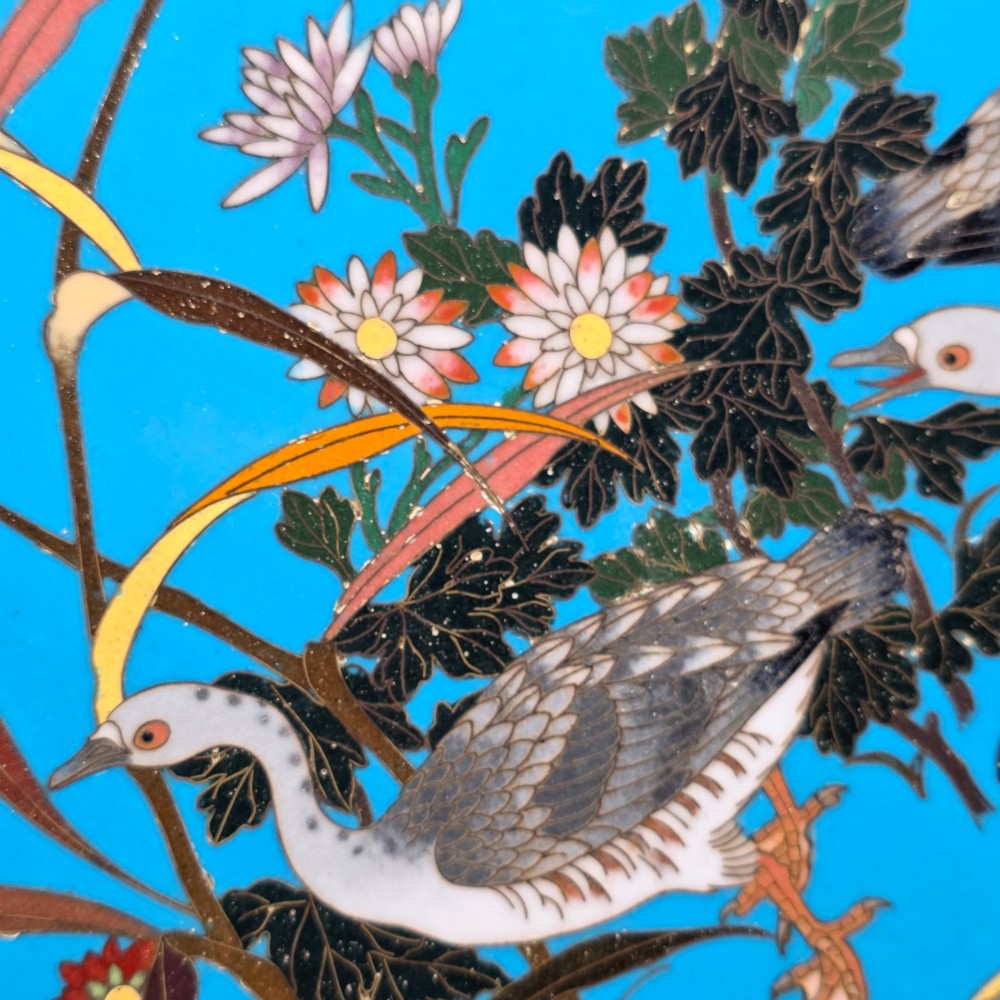 A circular Japanese cloisonne enamel charger depicting three wild geese amidst chrysanthemums against a vivid turquoise background. View X