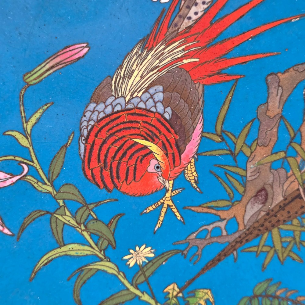 A circular Japanese Meiji period cloisonne enamel charger depicting birds perched on branches with flowers against a bright blue background. View VI
