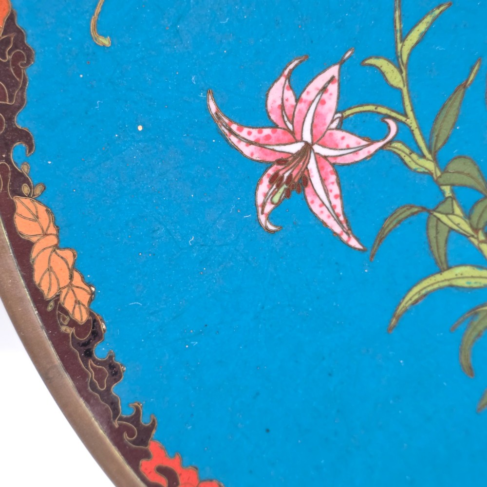 A circular Japanese Meiji period cloisonne enamel charger depicting birds perched on branches with flowers against a bright blue background. View X