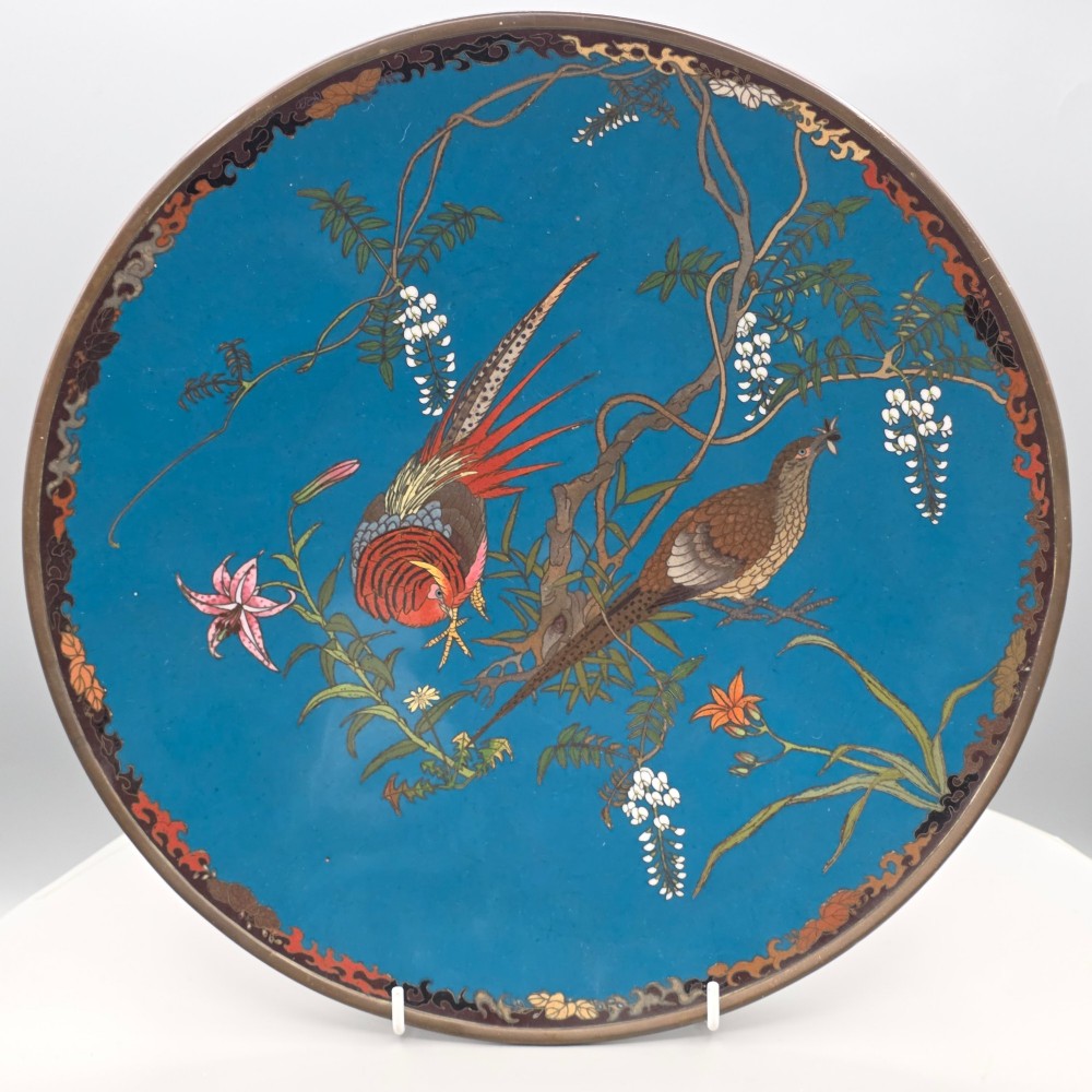 A circular Japanese Meiji period cloisonne enamel charger depicting birds perched on branches with flowers against a bright blue background. View XV