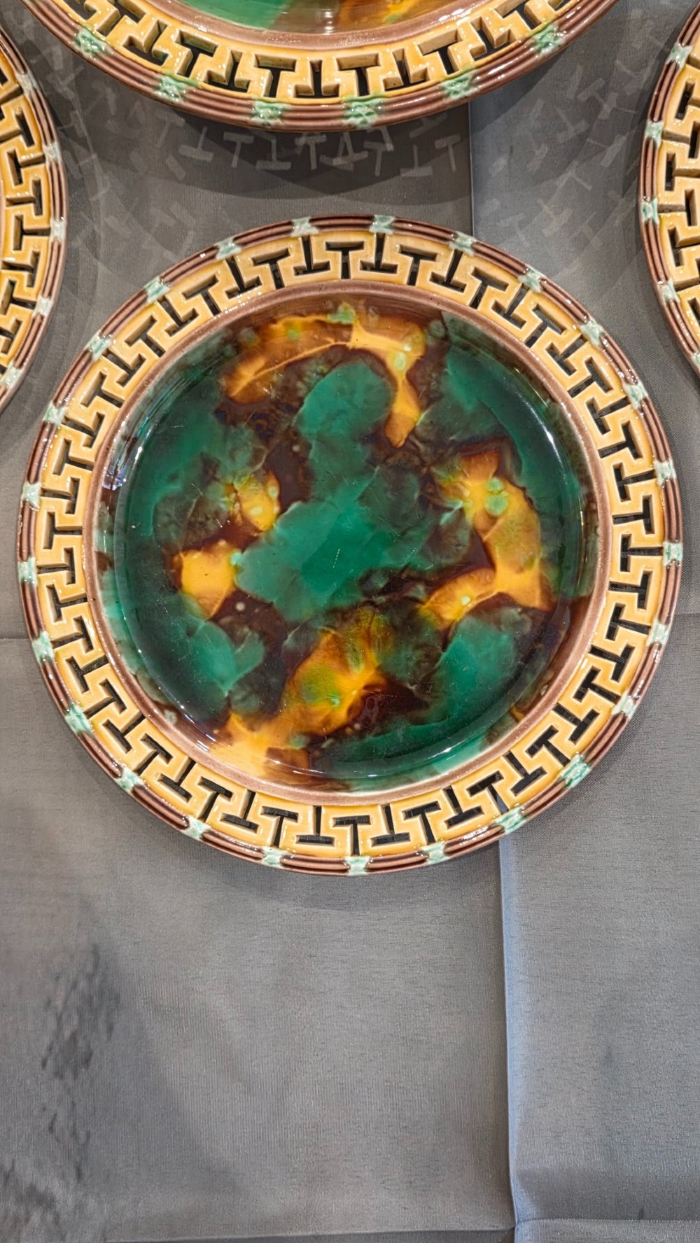 A ten-piece nineteenth-century Wedgwood majolica dessert service featuring green and brown mottled glazes surrounded by classical Greek key pattern borders. View X