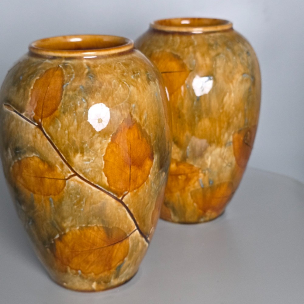 A pair of Edwardian baluster-shaped stoneware vases with warm ochre glaze and impressed leaf motifs. View V