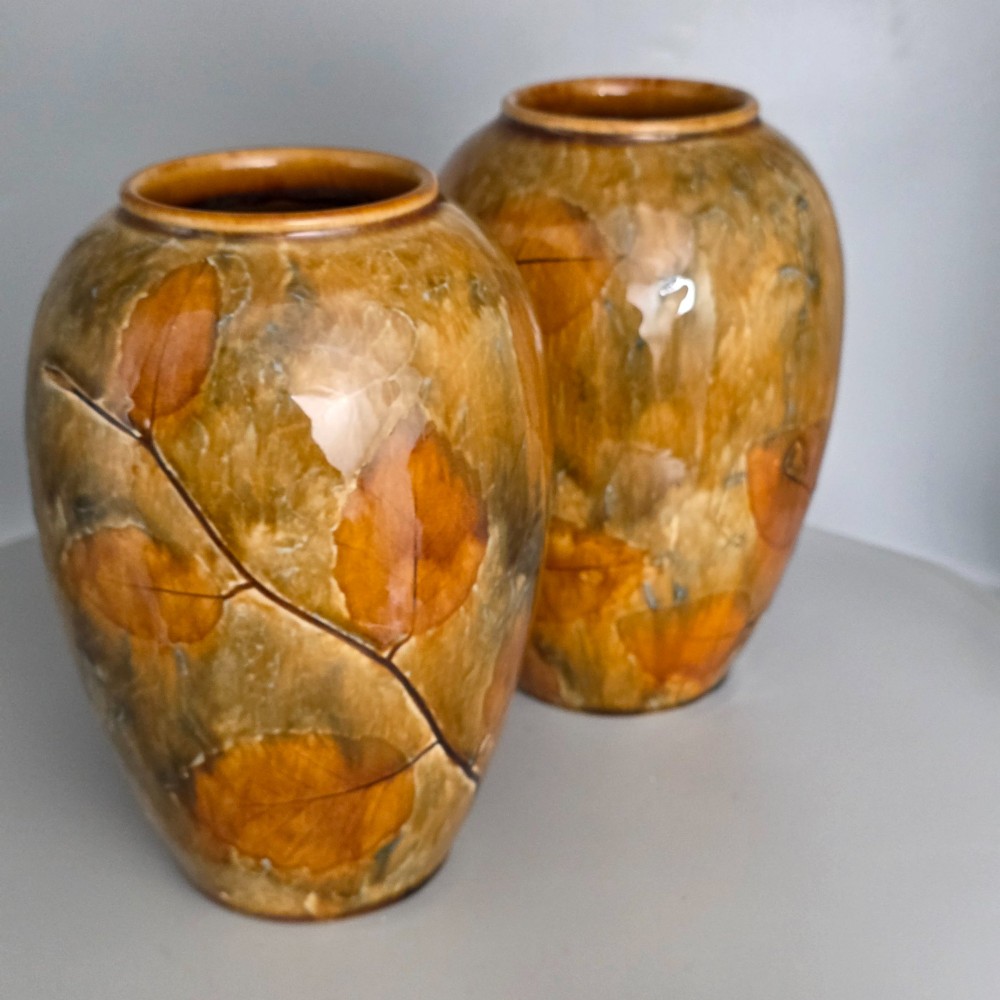 A pair of Edwardian baluster-shaped stoneware vases with warm ochre glaze and impressed leaf motifs. View VI