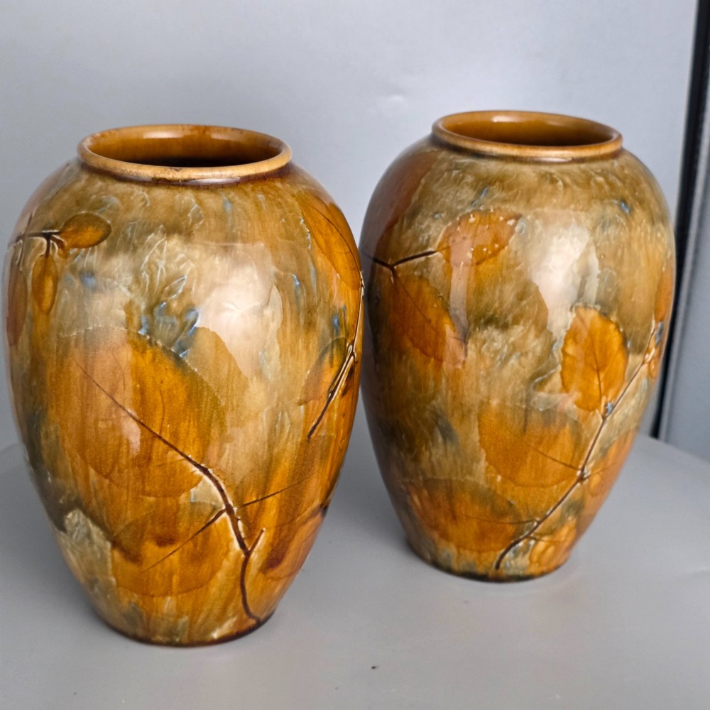 A pair of Edwardian baluster-shaped stoneware vases with warm ochre glaze and impressed leaf motifs. View X