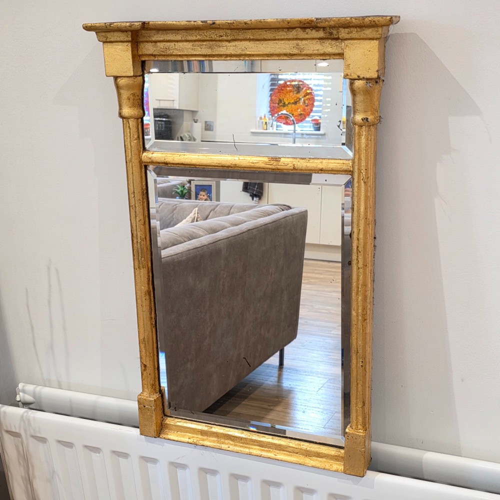 A rectangular Regency style giltwood pier mirror featuring side columns, an architectural cornice, and a two-section glass mirror plate. View II