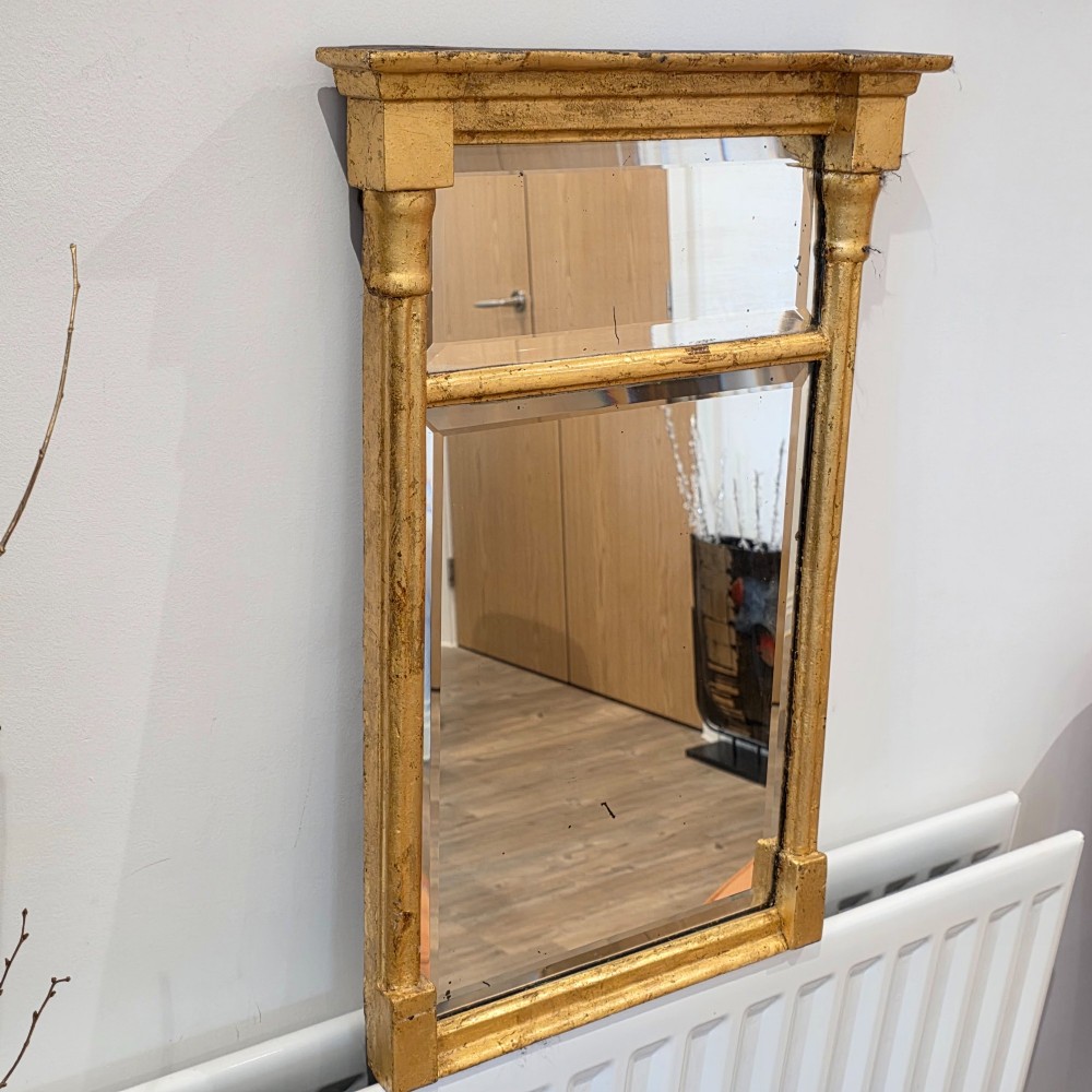 A rectangular Regency style giltwood pier mirror featuring side columns, an architectural cornice, and a two-section glass mirror plate. View VI