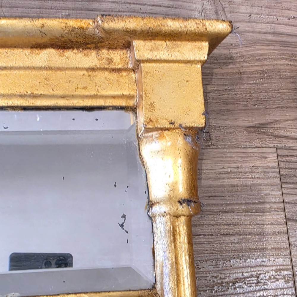 A rectangular Regency style giltwood pier mirror featuring side columns, an architectural cornice, and a two-section glass mirror plate. View III