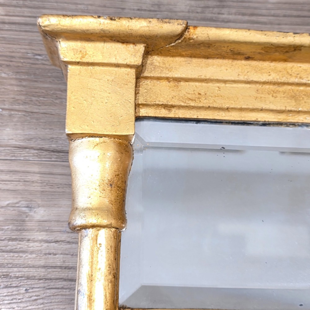 A rectangular Regency style giltwood pier mirror featuring side columns, an architectural cornice, and a two-section glass mirror plate. View X