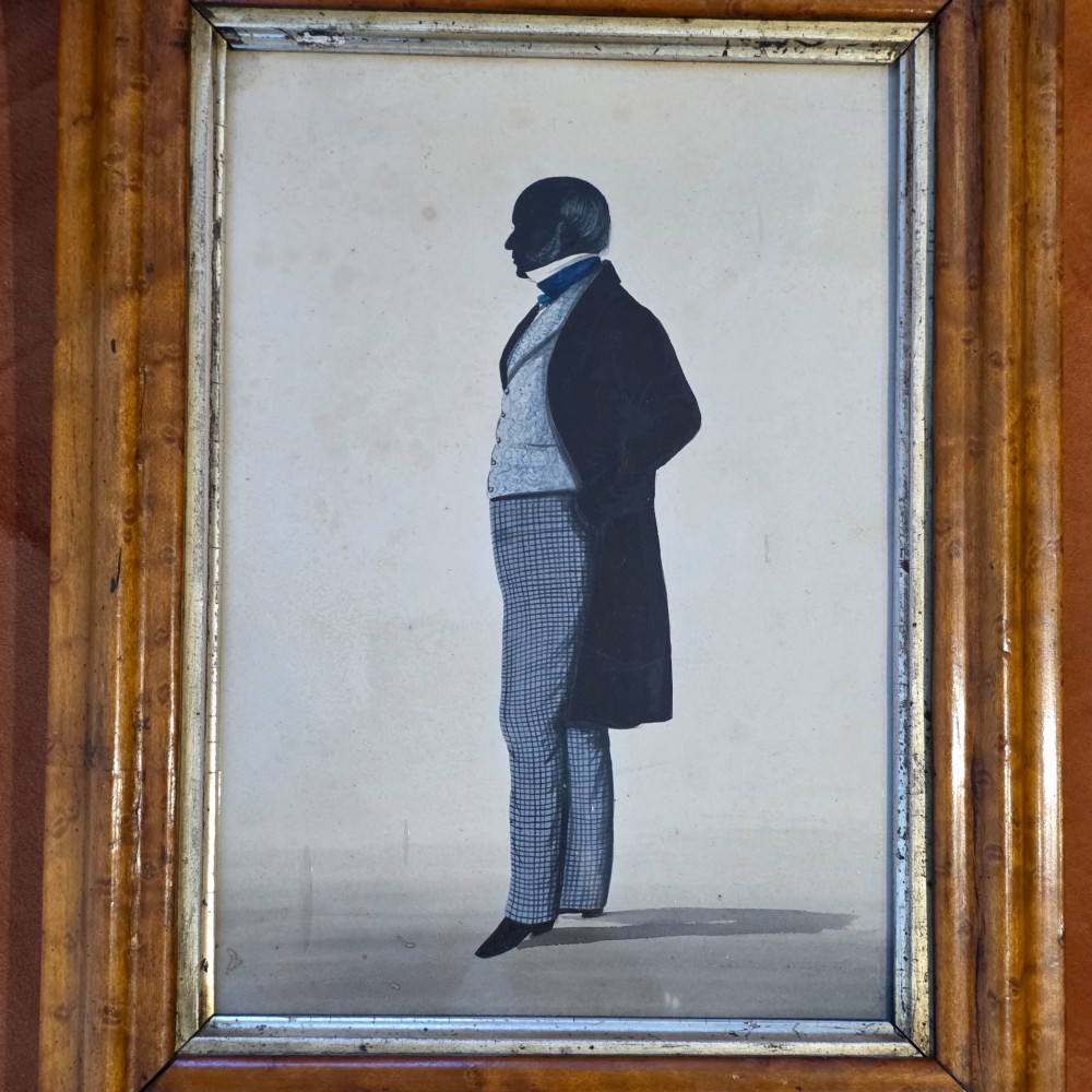 A framed full-length silhouette portrait of a gentleman in 19th-century costume presented in a birds eye maple frame. View IV