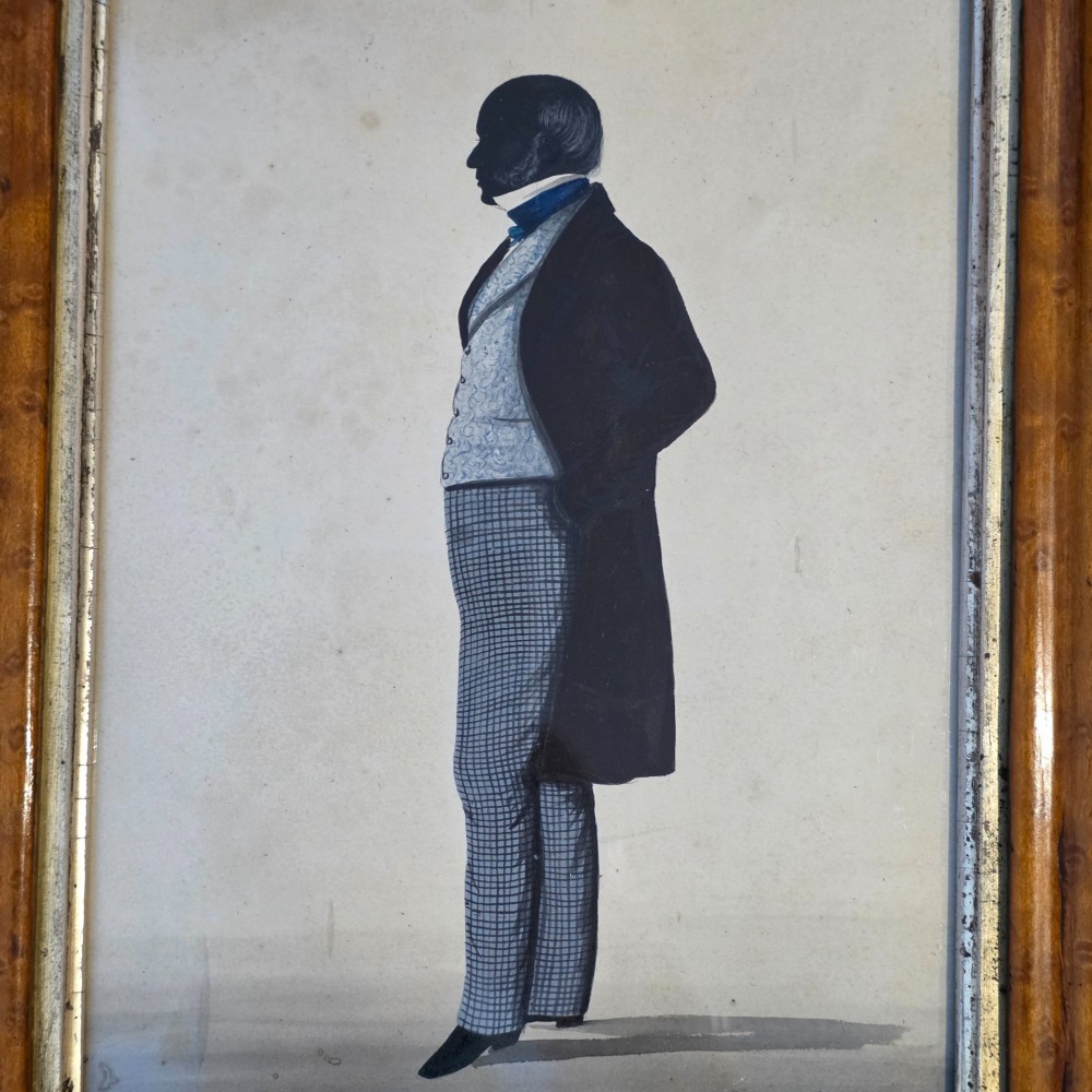 A framed full-length silhouette portrait of a gentleman in 19th-century costume presented in a birds eye maple frame. View V