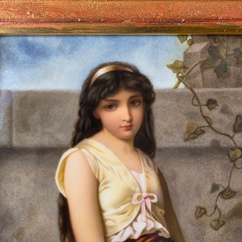 A rectangular hand-painted porcelain plaque depicting a young woman with a tambourine, set within a thick moulded gilt frame. View IX